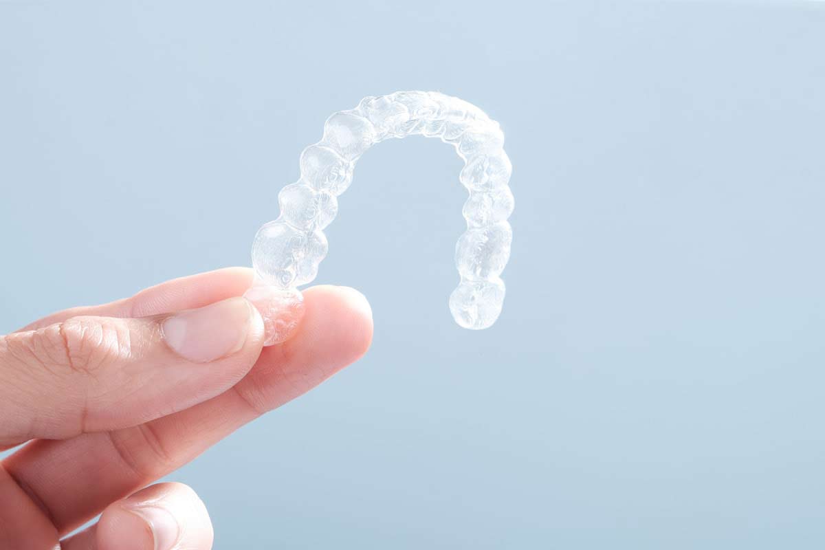 person holding their new clear aligners